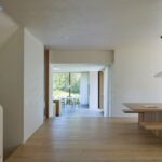 Otvorený obytný priestor s dubovou podlahou a priehľadom cez veľkoformátové okno do záhrady.