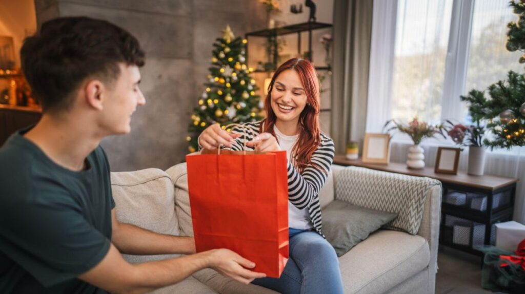 Mladý muž dáva darčekovú tašku mladej žene.