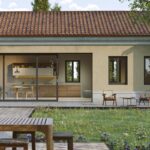 Moderný bungalov s presklenými posuvnými dverami a sedením na terase.