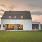 Moderný dom so sedlovou strechou a veľkoformátovými oknami.