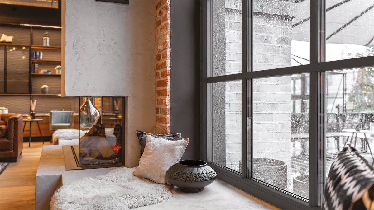 Sedenie pod vysokým deleným oknom v modernm interiéri.