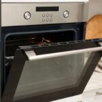 Moderná rúra s otvorenými dvierkami.