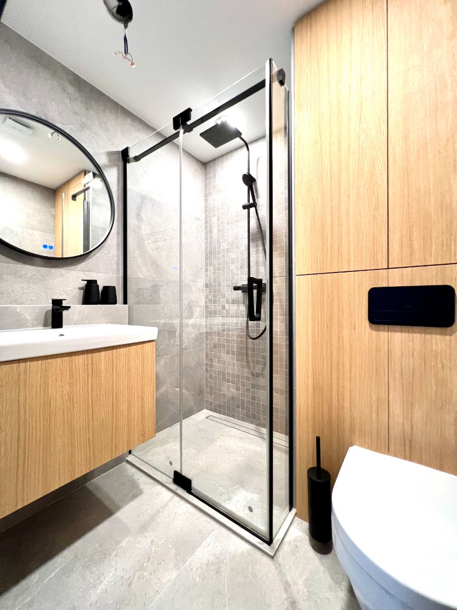 V kúpeľni je skombinované drevo s gresovým obkladom imitujúcim kameň.