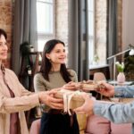 Muž odovzdáva dary pri návšteve dvoch žien.