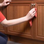 Detail na utieranie skrinky kuchynskej linky mikrovláknovou utierkou.