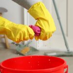 Žmýkanie vody z mikrovláknovej utierky do vedra.