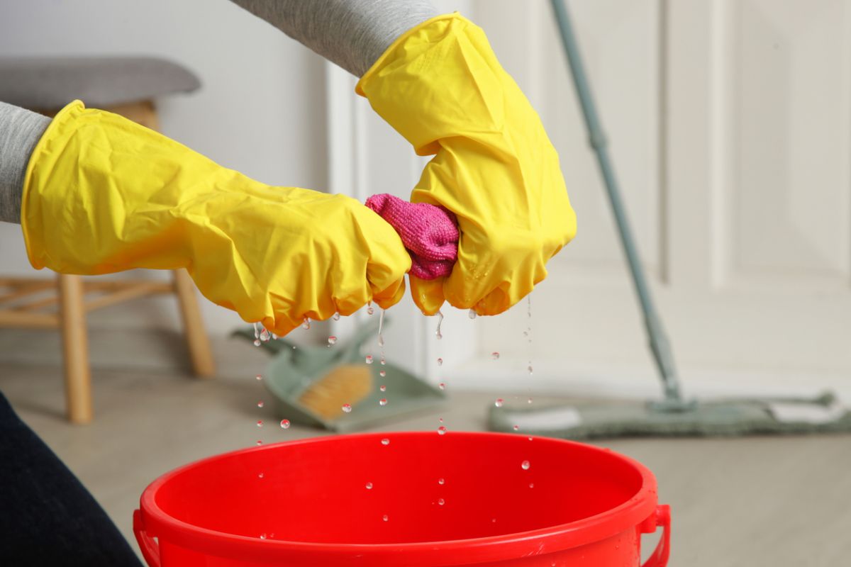 Žmýkanie vody z mikrovláknovej utierky do vedra.