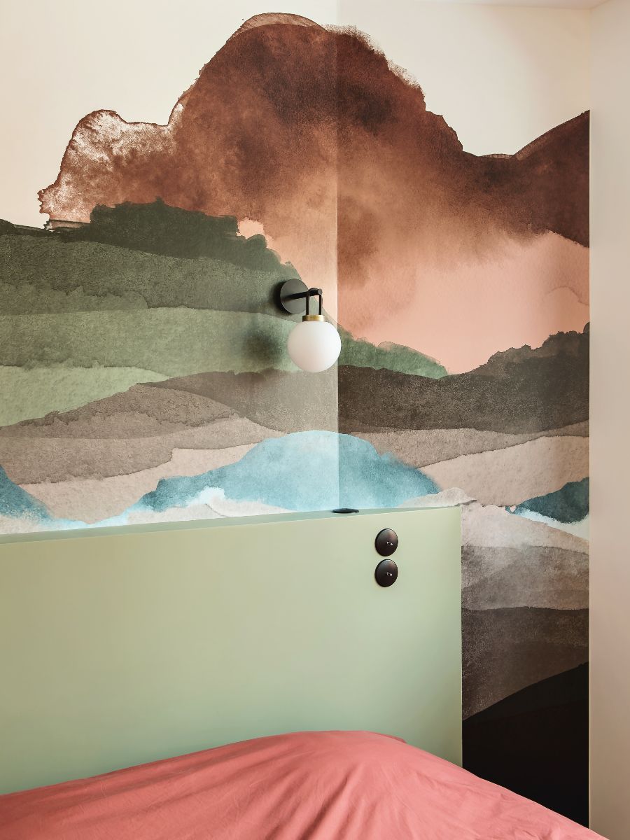 Spálňu na prízemí vkusne oživuje farebná tapeta.