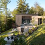 Moderné sídlo v lesnom prostrední s drevenou fasádou a posedením pri ohnisku