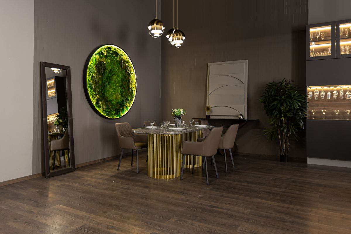 Luxusný mramorový stôl so zlatou podnožou, hnedé kožené kreslá a svietiaci kruhový machový obraz.