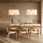 Kuchyňa s dolnými skrinkami a zástenou z prítomného kameňa za dreveným jedálenským stolom.