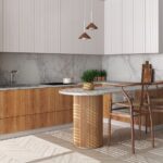 Modená kuchyňa s bielymi a drevenými skrinkami a pultom s valcovitou podperou a barovým sedením.