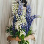 Žena drží v rukách pred tvárou kyticu zo stračonôžok.