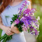 Žena drží v ruke kyticu zo stračonôžok.