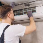 Pracovník pri kontrole klimatizačnej jednotkuý.