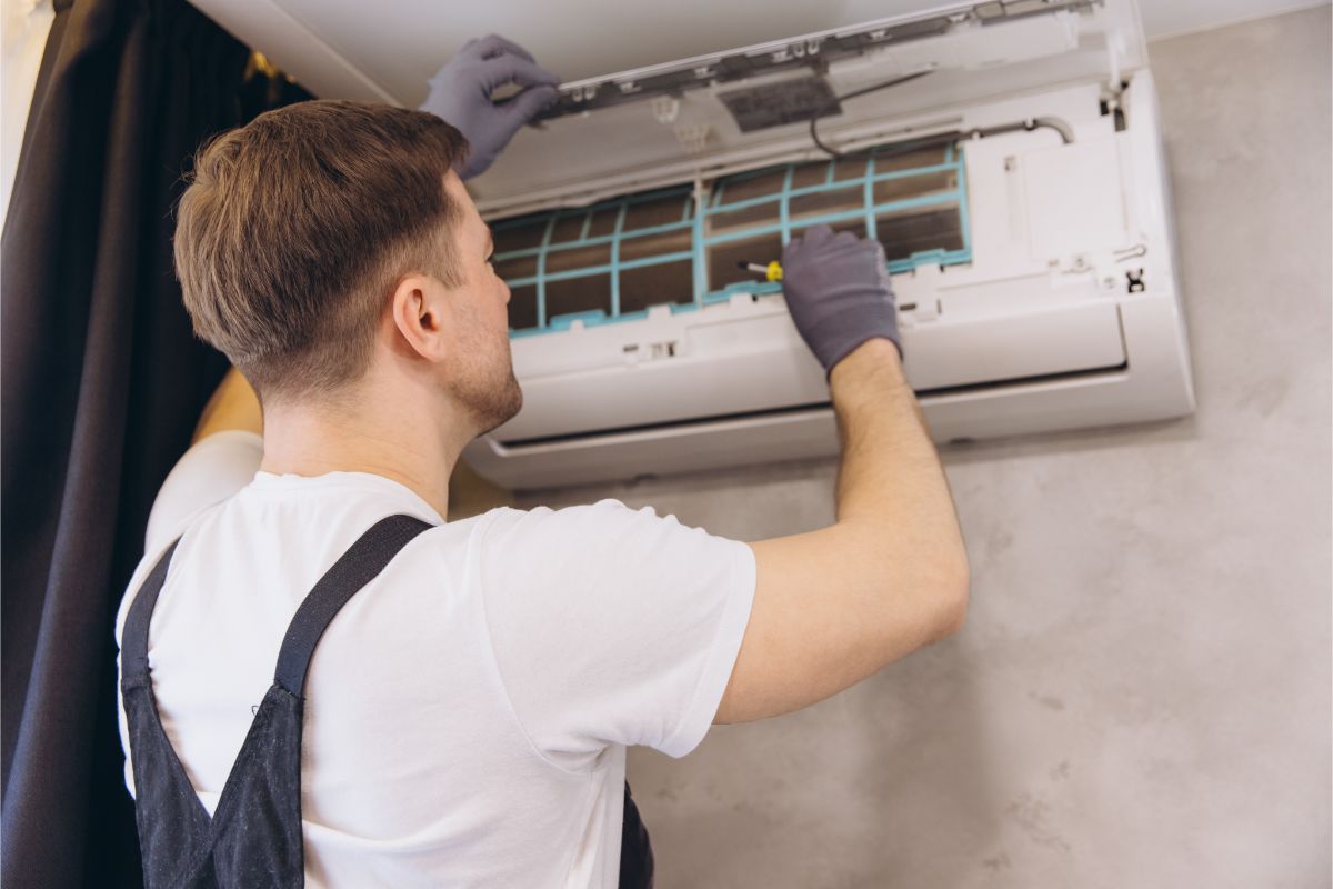 Pracovník pri kontrole klimatizačnej jednotkuý.