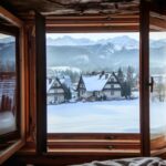 Otvorené okno s výhľadom do zimnej krajiny.