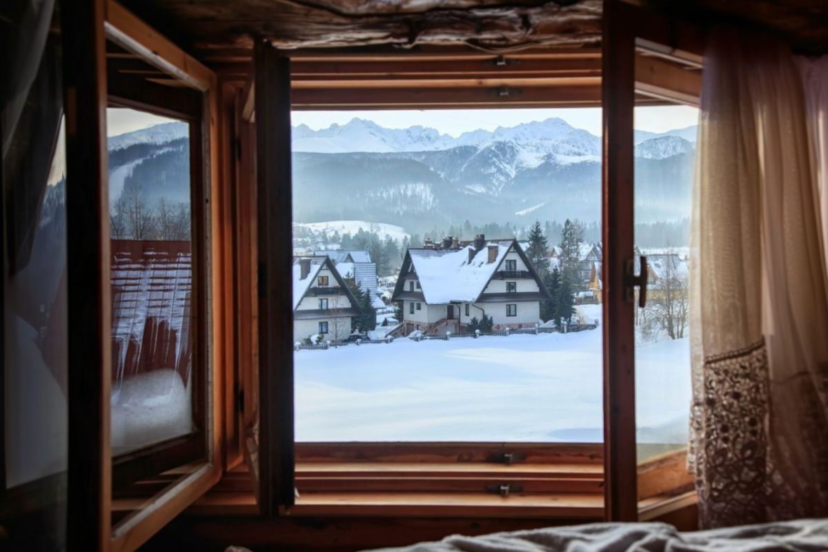 Otvorené okno s výhľadom do zimnej krajiny.