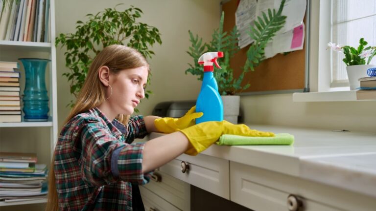 Žena utiera prach handrou a prípravkom v spreji.