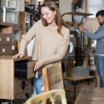 Žena pri prezeraní nábytku z druhej ruky v bazáre.