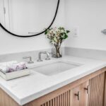 Skrinka v kúpeľni so zapusteným umývadlom a doskou z kremeňa.