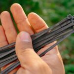 Ruka držiaca čierne sťahovacie pásky.