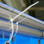 Detail na kryciu plachtu, zaistenú o kovovú konštrukciu sťahovacou páskou.