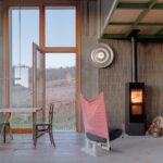 Moderné čierne kachle pri betónovej stene a dverách na terasu