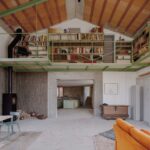 Priestranná obývacia izba s oceľovou galériou, zelenou knižnicou, betónovými prvkami.