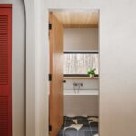 Pohľad z chodby cez otvorené dvere do kúpeľne s vaňou a grafickou dlažbou.