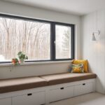 hnedá lavica s úložným priestorom pod oknom s výhľadom na les.