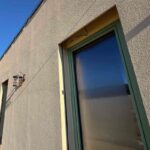 Fasáda jednopodlažného domu s vysokými oknami v príprave na vonkajšie žalúzie.