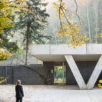 Uličná fasáda domu s gabiónovými stenami a betónovými stĺpmi v tvare V,