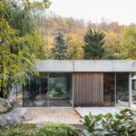 Časť domu Banánka s presklenou a drevenou fasádou pri terase a upravenej záhrade.