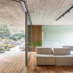 Priechod medzi interiérom a exteriérom cez odsunutú sklenenú fasádu.