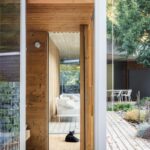 Úzky priechod medzi stĺpmi a múrmi drevenej terasy, vedúcej na záhradu.