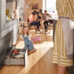 Sivá kuchynská linka s praktickým soklovým výsuvom a kovovými formami na pečenie.