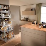 Otvorená béžová potravinová skriňa so sivými výsuvnými zásuvkami.