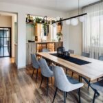 Masívny dubový stôl so sivými stoličkami a presklená podsvietená vitrína v minimalistickej jedálni.