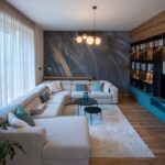 Sivá rohová sedačka, modrá obývacia stena a tmavá umelecká tapeta v modernom mestskom byte.