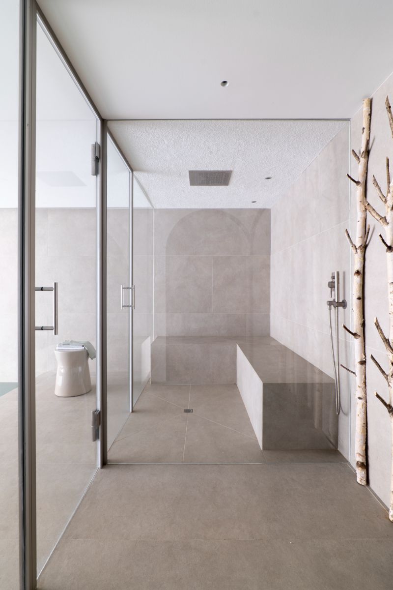 Všimnite si orezané konáre stromov, ktoré slúžia zrejme ako vešiaky na oblečenie či osušky. Funkčný spôsob, ako vniesť dovnútra viac prírodných prvkov.