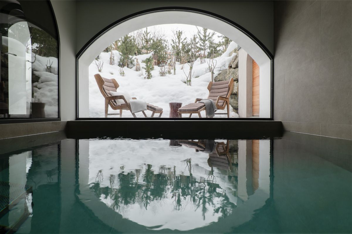 Elegantné oblúkové okno s výhľadom do prírody umocňuje relaxačnú atmosféru.