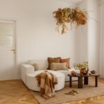 Moderná kuchyňa s dreveným ostrovom, bielymi skrinkami, masívnym jedálenským stolom a tromi závesnými lampami.