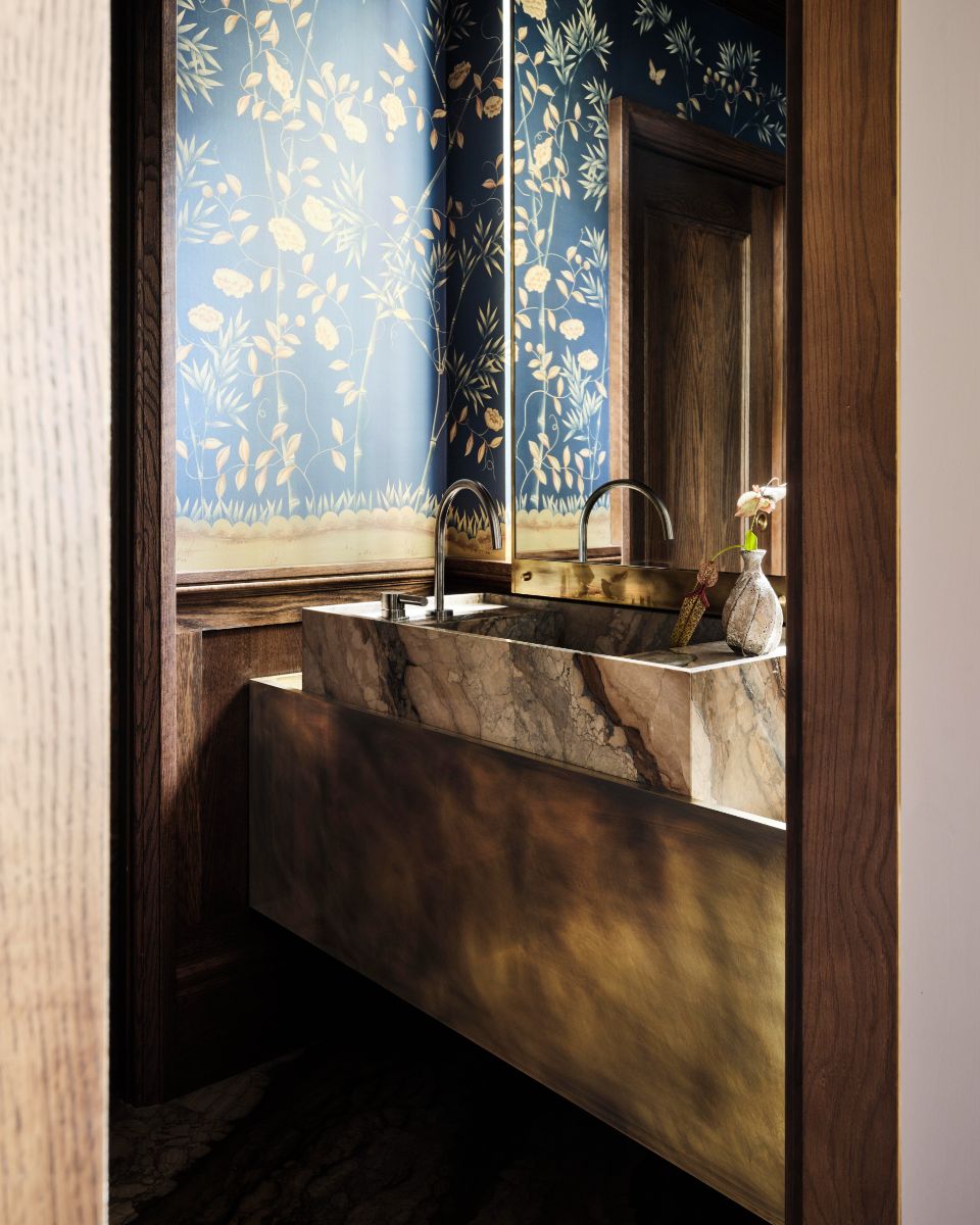 Pri dizajne sídla na spoločenské účely si štúdio dalo záležať ešte aj na toalete pre hostí. Definuje ho tmavá farebnosť, kvalitné materiály, drevené obloženie a podmanivá tapeta s rastlinným vzorom.