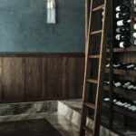 Vinotéka v polici z tmavého dreva na mramorovom schode s rebríkom.