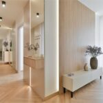 Chodba s nízkou skrinkou a samonosnou policou s kvetmi.