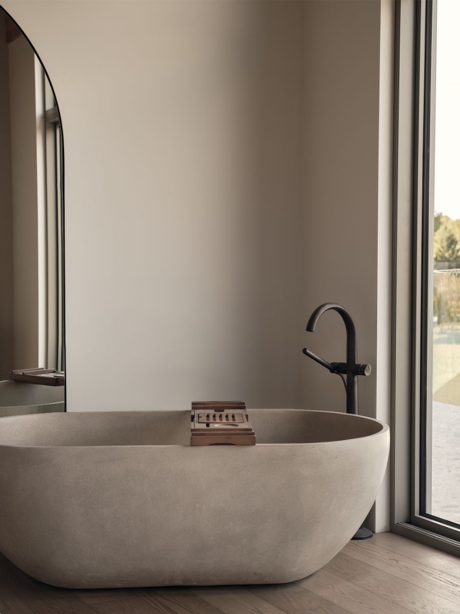 Súčasťou spálne pre hostí je aj samostatne stojaca moderná vaňa s výhľadom na krajinu.