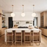 Kuchyňa s dreveným ostrovom, mramorovou pracovnou doskou, bielymi guľovými lampami a prútenými barovými stoličkami.