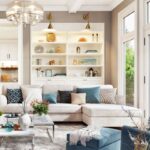 Svetlá rohová sedačka pred mramorovým konferenčným stolíkom pod skleneným lustrom v bielom otvorenom interiéri.