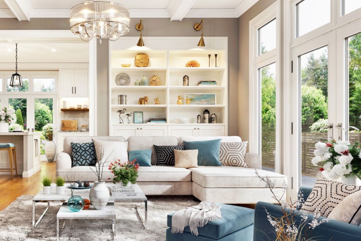 Svetlá rohová sedačka pred mramorovým konferenčným stolíkom pod skleneným lustrom v bielom otvorenom interiéri.